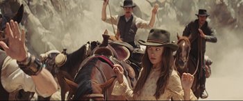 Movie still from “Cowboys & Aliens” (2011), directed by Jon Favreau – A woman riding on the back of a horse; Medium shot, Over the shoulder angle