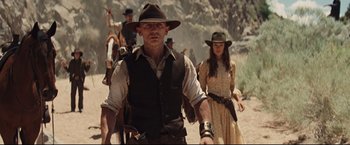 Movie still from “Cowboys & Aliens” (2011), directed by Jon Favreau – A group of people walking down a dirt road; Medium shot, Low angle