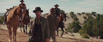 Movie still from “Cowboys & Aliens” (2011), directed by Jon Favreau – A man in a suit and a hat on a dirt road; Medium shot, Low angle