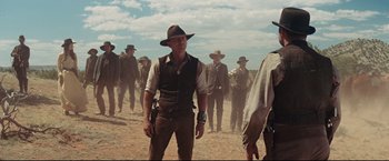 Movie still from “Cowboys & Aliens” (2011), directed by Jon Favreau – A group of men standing on top of a dirt field; Medium shot, Low angle