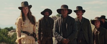 Movie still from “Cowboys & Aliens” (2011), directed by Jon Favreau – A group of men and women wearing hats and suits; Medium shot, Low angle
