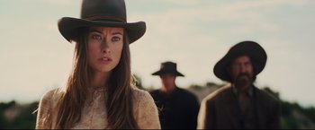Movie still from “Cowboys & Aliens” (2011), directed by Jon Favreau – A woman in a cowboy hat standing next to a man in a cowboy hat; Close Up shot, Over the shoulder angle