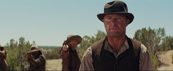 Movie still from “Cowboys & Aliens” (2011), directed by Jon Favreau – A man in a cowboy hat and a man with a gun in his hand; Medium shot, Over the shoulder angle