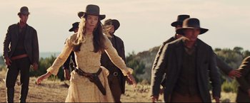 Movie still from “Cowboys & Aliens” (2011), directed by Jon Favreau – A group of people walking in a field with guns; Medium shot, Low angle