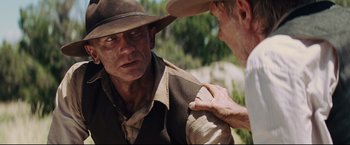 Movie still from “Cowboys & Aliens” (2011), directed by Jon Favreau – A man in a cowboy hat is looking at another man in a cowboy hat; Close Up shot, Over the shoulder angle