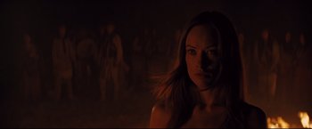 Movie still from “Cowboys & Aliens” (2011), directed by Jon Favreau – A woman is standing in a dark room; Close Up shot, Over the shoulder angle