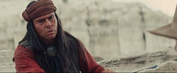 Movie still from “Cowboys & Aliens” (2011), directed by Jon Favreau – A native american sitting on top of a cliff; Close Up shot, Over the shoulder angle