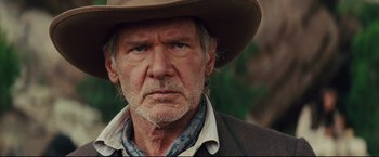Movie still from “Cowboys & Aliens” (2011), directed by Jon Favreau – An older man wearing a cowboy hat and looking at the camera; Close Up shot, Over the shoulder angle