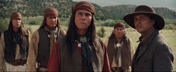 Movie still from “Cowboys & Aliens” (2011), directed by Jon Favreau – A group of native american men standing in a field; Medium shot, Over the shoulder angle