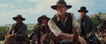 Movie still from “Cowboys & Aliens” (2011), directed by Jon Favreau – A group of men riding horses down a dirt road; Medium shot, Low angle