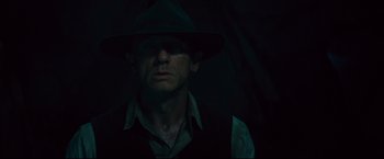 Movie still from “Cowboys & Aliens” (2011), directed by Jon Favreau – A man wearing a hat in the dark; Close Up shot, Over the shoulder angle