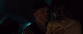 Movie still from “Cowboys & Aliens” (2011), directed by Jon Favreau – A man in a hat is holding a woman in her arms; Close Up shot, Over the shoulder angle