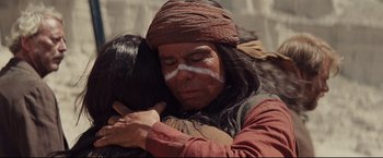 Movie still from “Cowboys & Aliens” (2011), directed by Jon Favreau – A native american man hugging another native american woman; Close Up shot, Over the shoulder angle