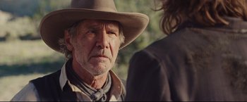Movie still from “Cowboys & Aliens” (2011), directed by Jon Favreau – An older man wearing a cowboy hat and a tie; Close Up shot, Over the shoulder angle