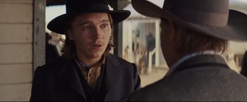 Movie still from “Cowboys & Aliens” (2011), directed by Jon Favreau – A man wearing a hat and a suit talking to another man in a hat; Close Up shot, Over the shoulder angle