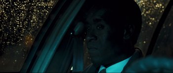 Movie still from “Crash” (2004), directed by Paul Haggis – A man in a suit sitting in a car looking out the window; Close Up shot, Low angle