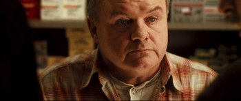 Movie still from “Crash” (2004), directed by Paul Haggis – An older man in a red and white plaid shirt; Close Up shot, Over the shoulder angle