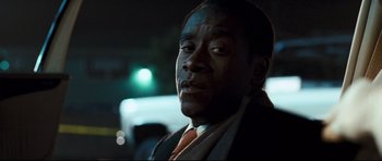 Movie still from “Crash” (2004), directed by Paul Haggis – A person wearing a suit and tie; Close Up shot, Over the shoulder angle
