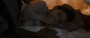 Movie still from “Crash” (2004), directed by Paul Haggis – A little girl laying on a bed next to a teddy bear; Close Up shot, High angle