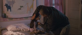 Movie still from “Crash” (2004), directed by Paul Haggis – A young girl getting her hair cut by a man; Medium shot, Over the shoulder angle