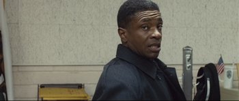 Movie still from “Crash” (2004), directed by Paul Haggis – A man in a black jacket is looking at the camera; Close Up shot, Over the shoulder angle