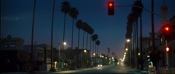 Movie still from “Crash” (2004), directed by Paul Haggis – A red traffic light sitting on the side of a road; Extreme Wide shot, Low angle