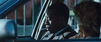 Movie still from “Crash” (2004), directed by Paul Haggis – A man sitting in a car with a cigarette in his mouth; Close Up shot, Over the shoulder angle