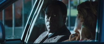 Movie still from “Crash” (2004), directed by Paul Haggis – A man sitting in the back seat of a car; Close Up shot, Over the shoulder angle