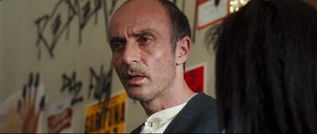 Movie still from “Crash” (2004), directed by Paul Haggis – A person wearing a suit and tie; Close Up shot, Over the shoulder angle