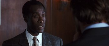 Movie still from “Crash” (2004), directed by Paul Haggis – A man wearing a suit and tie talking to a woman; Close Up shot, Over the shoulder angle