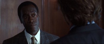 Movie still from “Crash” (2004), directed by Paul Haggis – A man wearing a suit and tie talking to another man in front of a mirror; Close Up shot, Over the shoulder angle