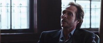 Movie still from “Crash” (2004), directed by Paul Haggis – A person wearing a suit and tie; Close Up shot, Over the shoulder angle