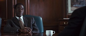 Movie still from “Crash” (2004), directed by Paul Haggis – A person sitting at a table with a cup of coffee; Close Up shot, Over the shoulder angle