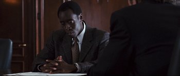 Movie still from “Crash” (2004), directed by Paul Haggis – A man sitting at a table in front of another man; Close Up shot, Over the shoulder angle