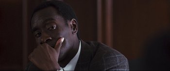 Movie still from “Crash” (2004), directed by Paul Haggis – A man sitting in a room with his hand under his chin; Close Up shot, Over the shoulder angle