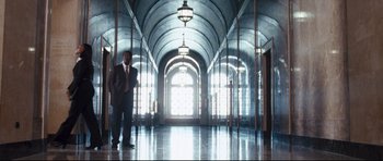 Movie still from “Crash” (2004), directed by Paul Haggis – A man in a suit standing in an empty hallway; Wide shot, Low angle