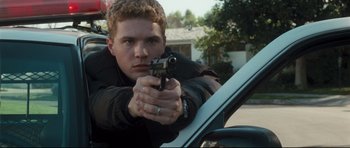 Movie still from “Crash” (2004), directed by Paul Haggis – A young man holding a gun in his hand; Close Up shot, High angle