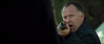 Movie still from “Crash” (2004), directed by Paul Haggis – A person holding a gun; Close Up shot, Over the shoulder angle