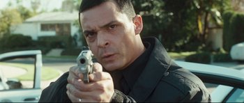 Movie still from “Crash” (2004), directed by Paul Haggis – A person holding a gun; Close Up shot, Low angle