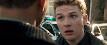 Movie still from “Crash” (2004), directed by Paul Haggis – A young man looking at a police officer in the street; Close Up shot, Over the shoulder angle