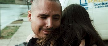 Movie still from “Crash” (2004), directed by Paul Haggis – A person hugging a man; Close Up shot, Over the shoulder angle