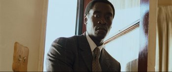 Movie still from “Crash” (2004), directed by Paul Haggis – A man wearing a suit and tie in front of a window; Close Up shot, Low angle