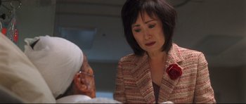 Movie still from “Crash” (2004), directed by Paul Haggis – A woman in a red jacket is looking at a man; Close Up shot, Over the shoulder angle