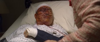 Movie still from “Crash” (2004), directed by Paul Haggis – A man with a bandaged head is laying in a hospital bed; Close Up shot, Overhead angle