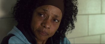 Movie still from “Crash” (2004), directed by Paul Haggis – An older woman with a headband on her head looking sad; Close Up shot, High angle
