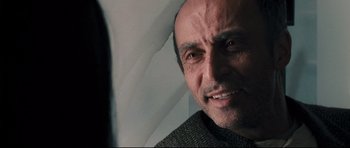 Movie still from “Crash” (2004), directed by Paul Haggis – A person smiling for the camera; Close Up shot, Over the shoulder angle