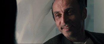 Movie still from “Crash” (2004), directed by Paul Haggis – A man smiling for the camera; Close Up shot, Low angle