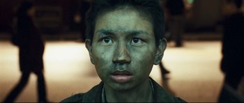 Movie still from “Crash” (2004), directed by Paul Haggis – A person wearing a green shirt; Close Up shot, High angle