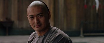 Movie still from “Crouching Tiger, Hidden Dragon” (2000), directed by Ang Lee – A man with a shaved head is looking at the camera; Close Up shot, Over the shoulder angle