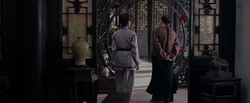 Movie still from “Crouching Tiger, Hidden Dragon” (2000), directed by Ang Lee – Two people standing in front of an archway in an oriental style building; Wide shot, Over the shoulder angle